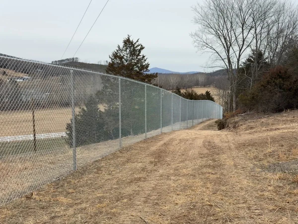 Fence line running downhill across pasture toward the mountains