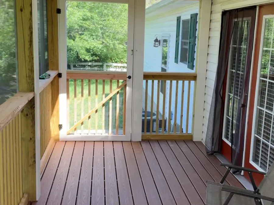 Screened porch interior with composite floor and screen door