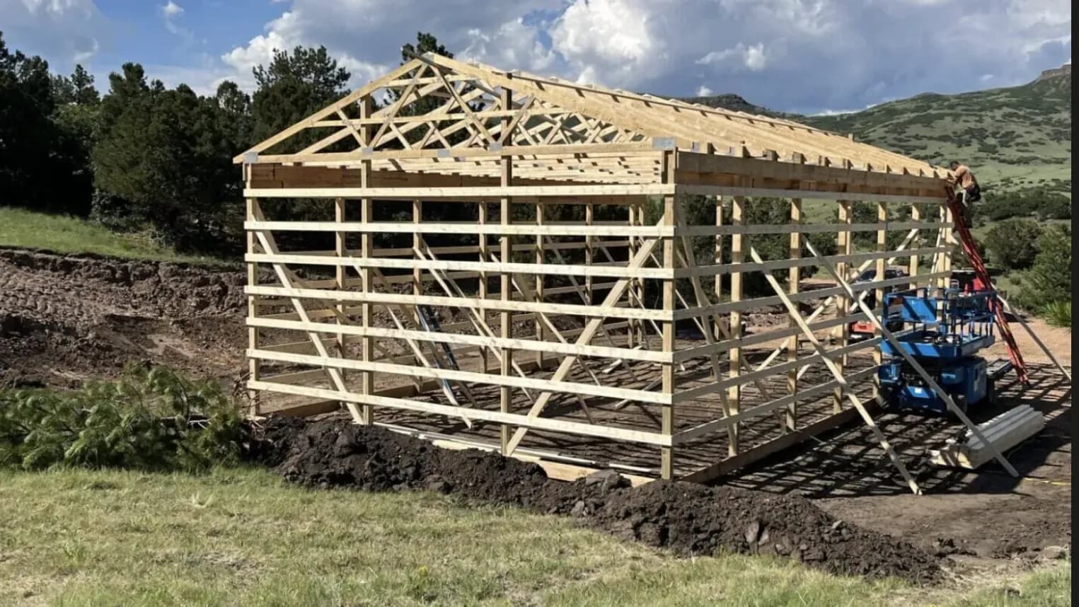 Post-frame pole barn with trusses and purlins set during construction