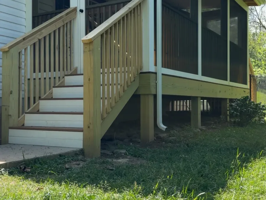 Finished screened porch addition with new wood stairs and white-framed screen panels
